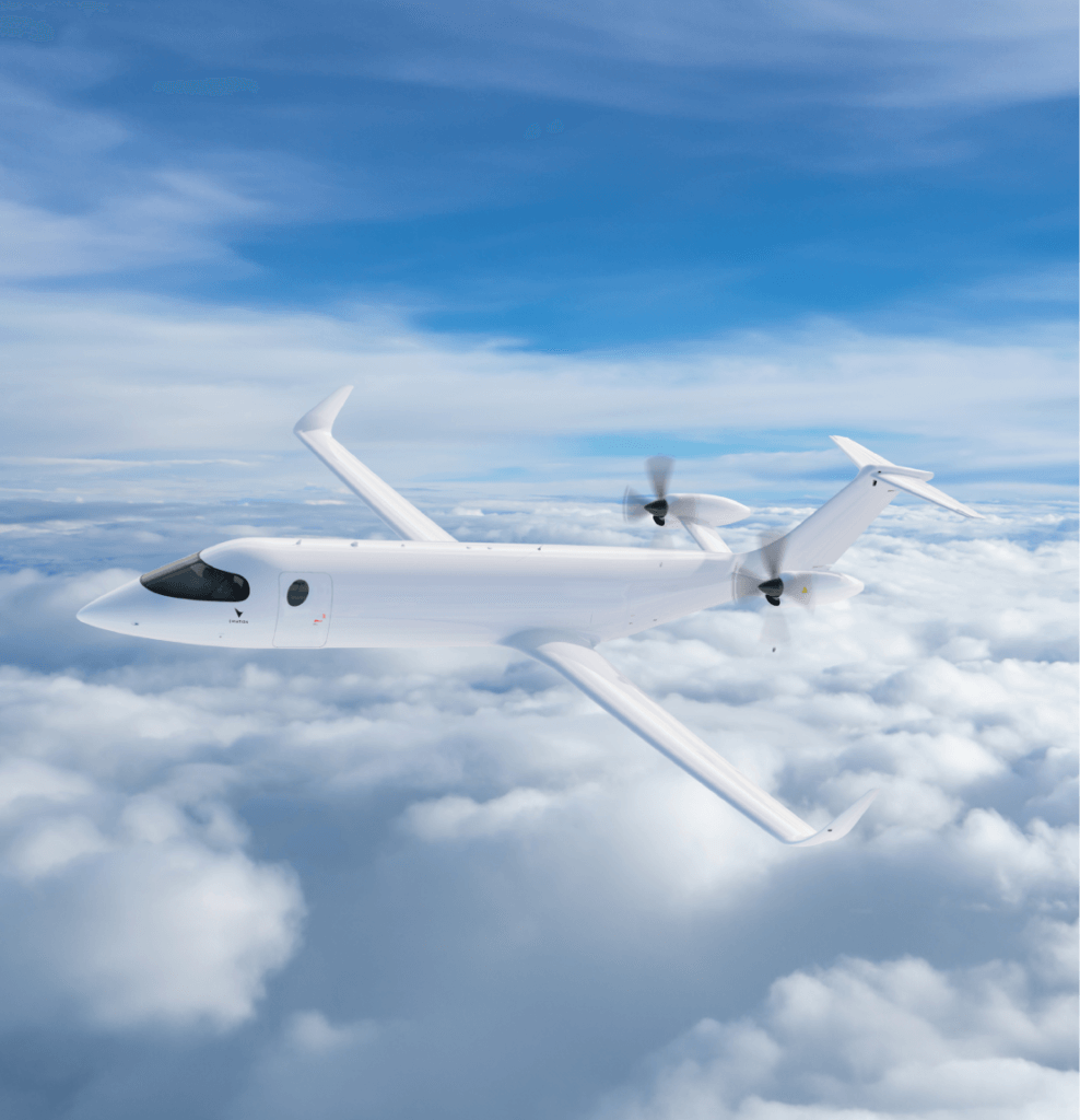Uma aeronave branca com dois motores a hélice montados na parte traseira está voando em um céu azul com nuvens brancas. A aeronave tem asas em V invertido e uma cauda em V.